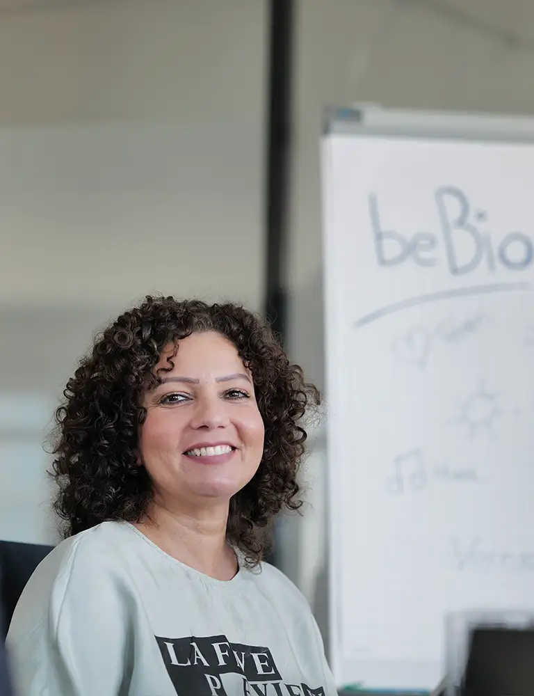 Frau mit Locken lächelnd im Workshop-Setting