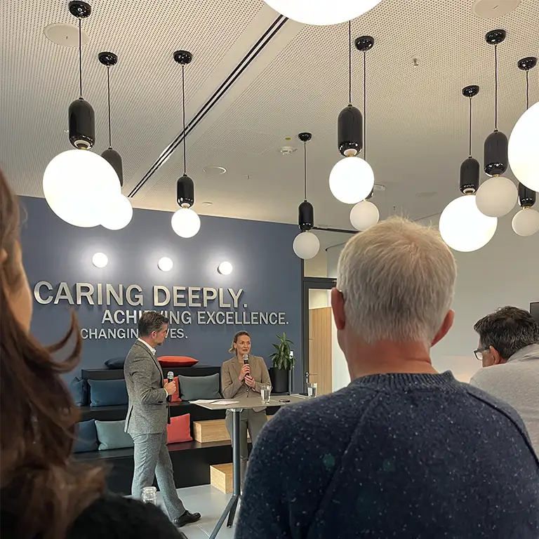 Gesundheitsministerin Gerlach wird von einem Biogen-Mitarbeiter vor der Belegschaft interviewed.