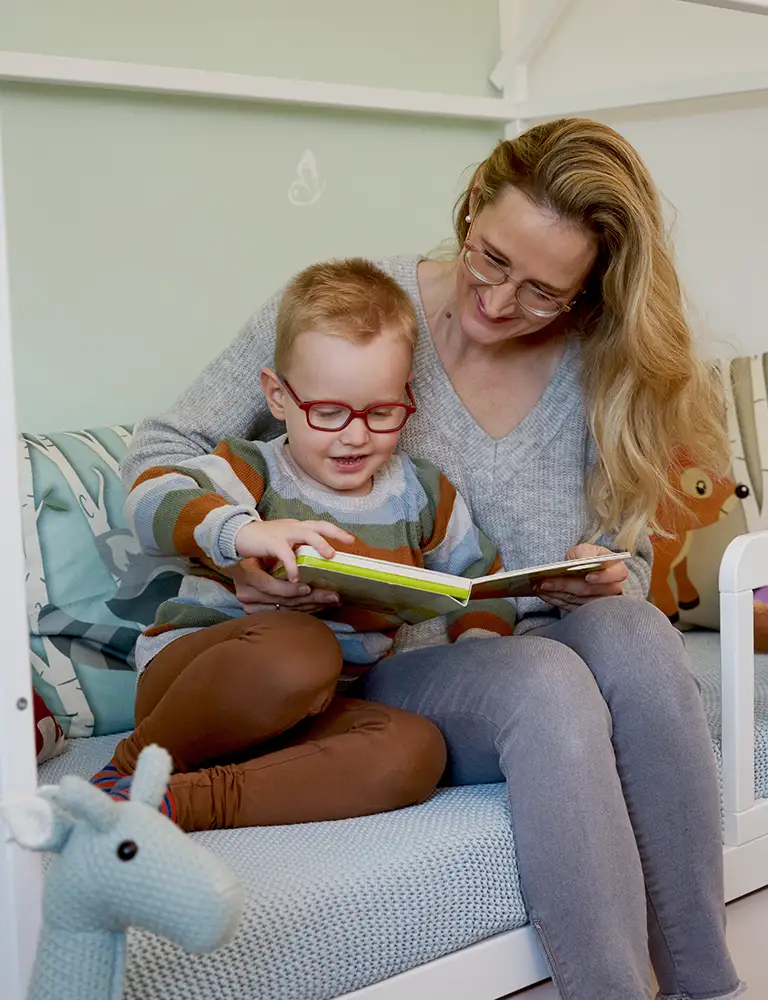 Rheuma-Patientin Yvonne liest mit ihrem Sohn ein Buch. 