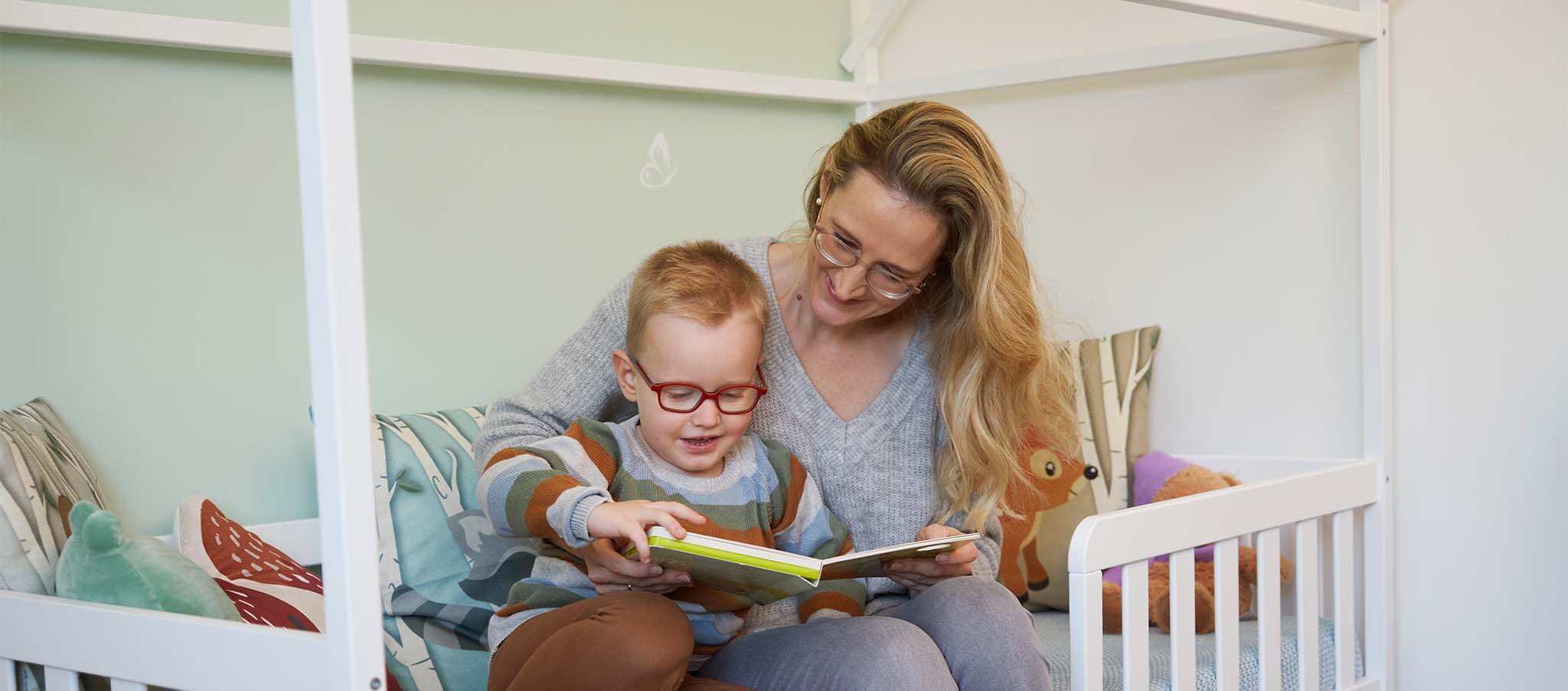 Rheuma-Patientin Yvonne liest mit ihrem Sohn ein Buch. 